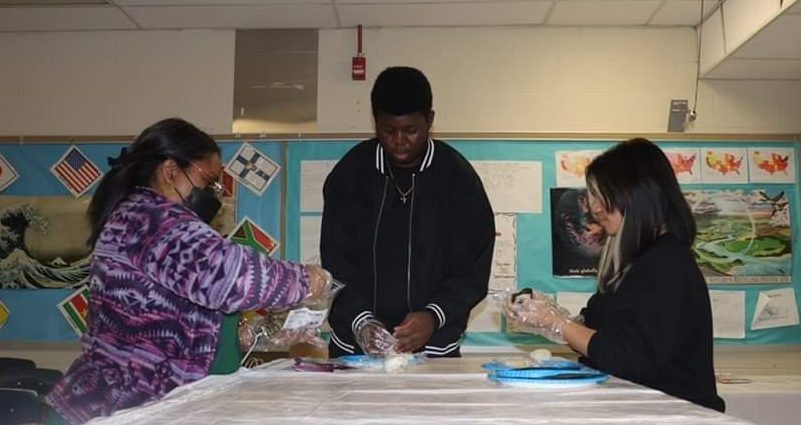 Former Parkdale student Jack-Kevin Hudelga (centered), who is still being taught by Ogata Sensai at UMBC, helps Ms. Lydia Abrue (left) and Jaylee Nguyen Tran with their Onigiri-making. (photo courtesy of Kenneth Pineda)