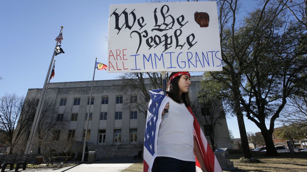 Observing a Day Without Immigrants, high school senior Vicky Sosa holds a sign outside the Grayson County courthouse in Sherman, Texas. (photo courtesy of NPR)